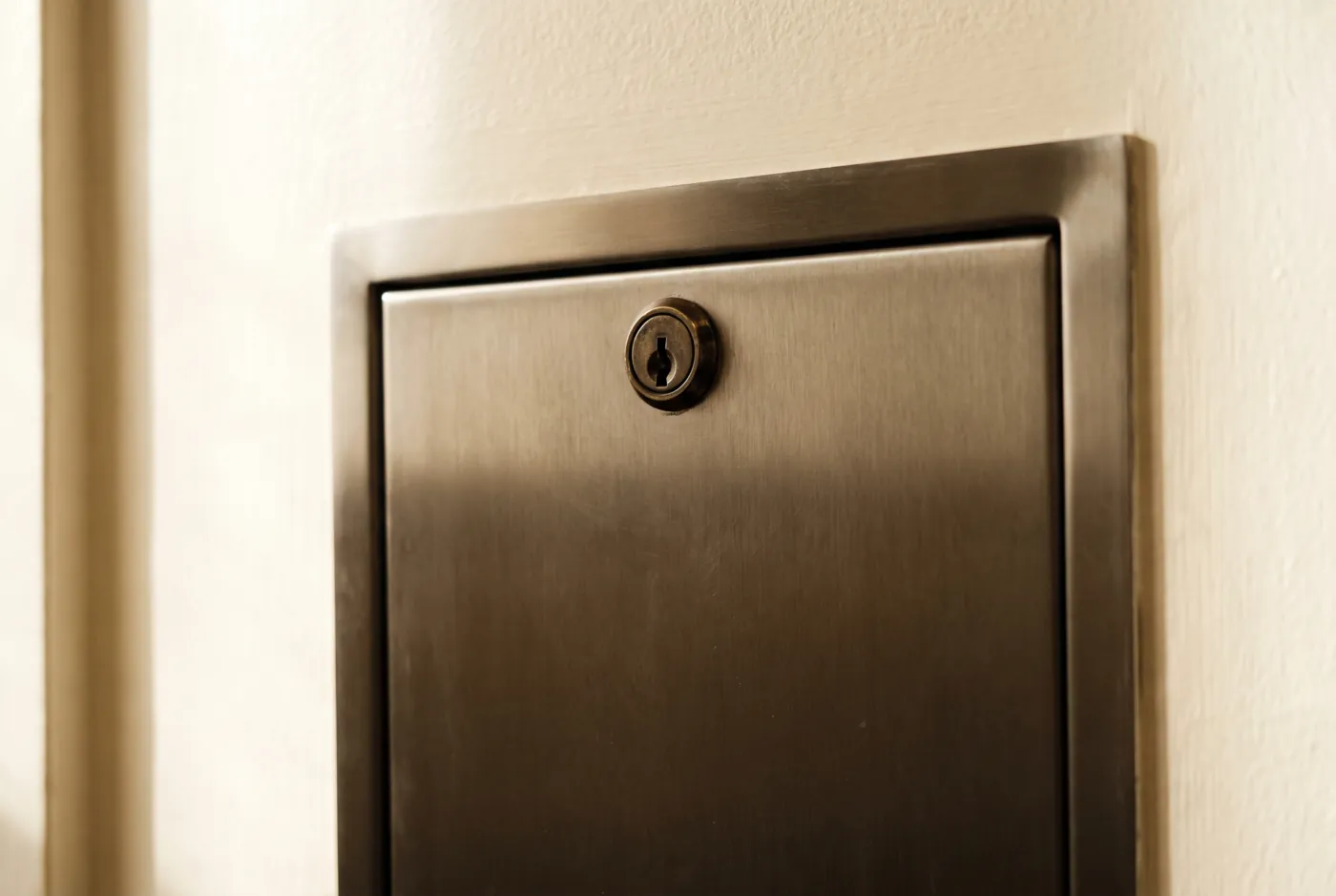 Détail architectural d'une porte de coffre en acier brossé, avec sa serrure ronde