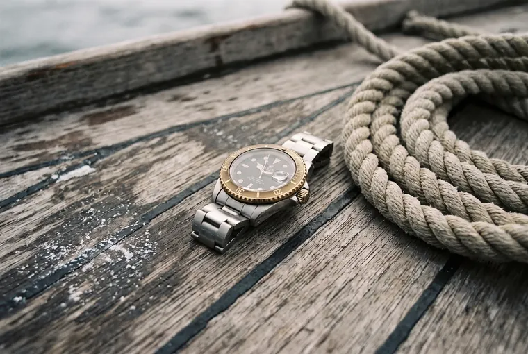 The diving watch resting on a boat's wooden deck, beside a coil of rope